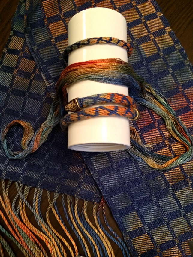 Silk Scarf Background - Kumihimo Bracelets and Thrums on Stand
